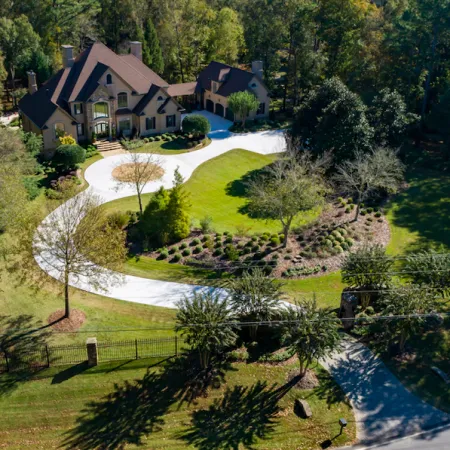 a house with a pond and trees around it