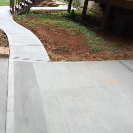 a concrete walkway with a wooden bridge