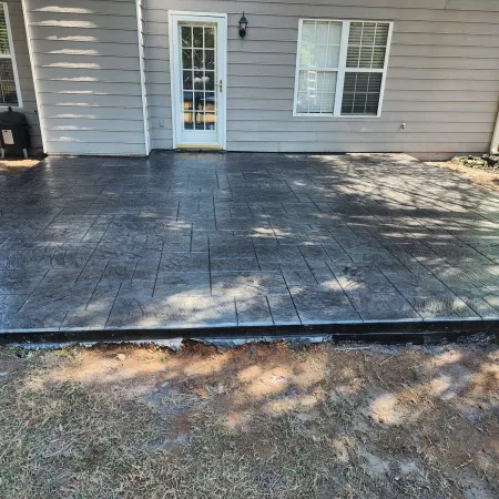 a deck with a wood deck and a house in the background