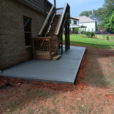 Poured concrete patio wrapping around the home and under the deck
