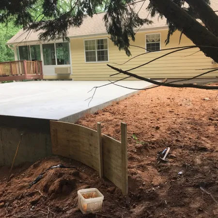 a house with a fence and dirt in front of it