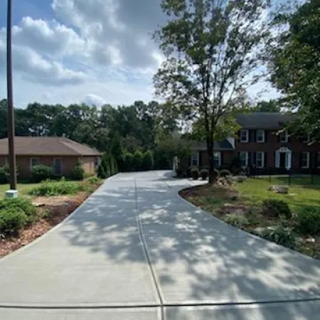 a sidewalk with trees and houses