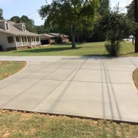 a paved area with a house in the background