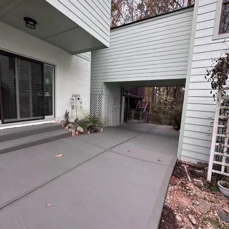 a house with a garage and a dog sitting on the porch