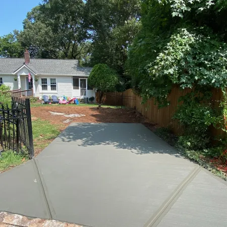 a driveway with a fence and trees