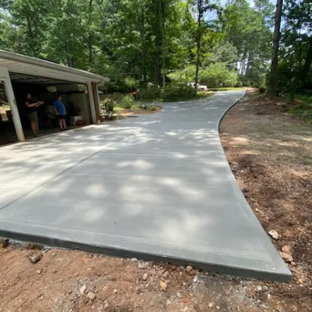 a concrete walkway with a building and trees in the background