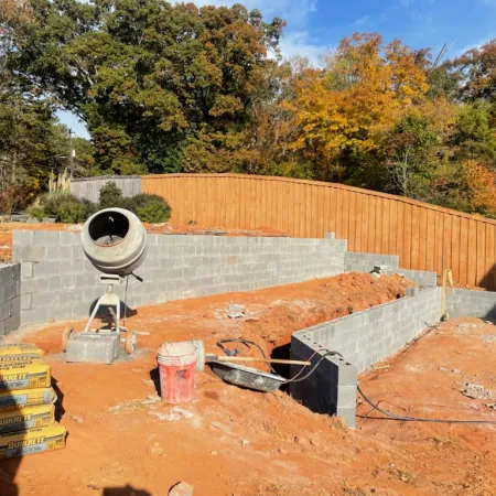 a backyard with a fence and a brick wall