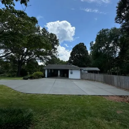 a house with a fence and trees around it