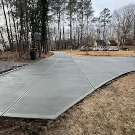 a concrete walkway with trees on either side of it