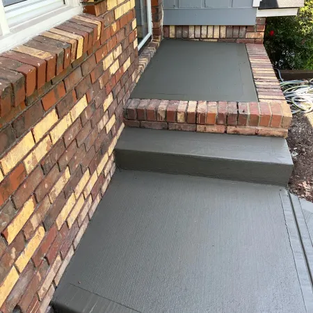 Concrete entryway with brick border matching home façade
