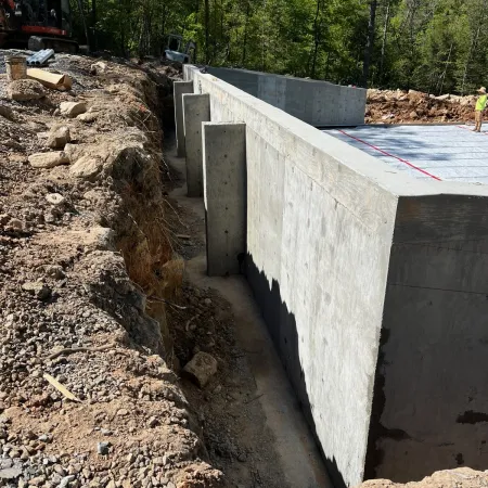 a concrete foundation with a pile of dirt and rocks