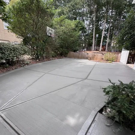 a driveway with trees and a fence