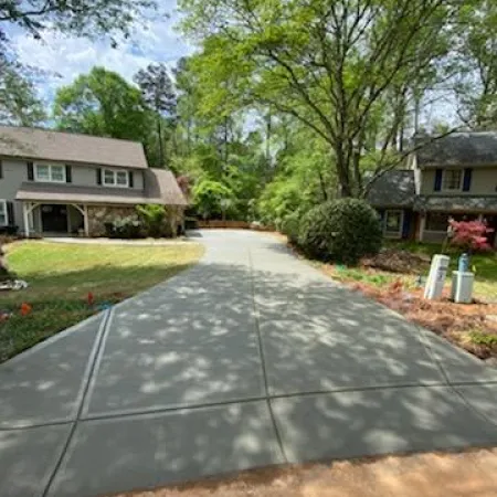 a driveway with a house and trees