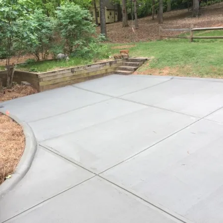 a concrete walkway with grass and trees