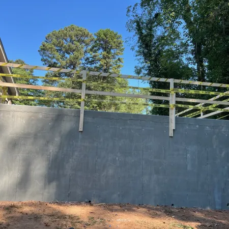 a concrete wall with a fence