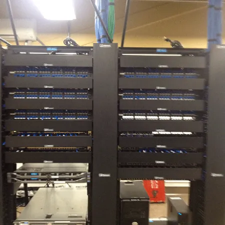 Server rack with network patch panels and connected Ethernet cables in a data center environment
