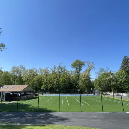 a tennis court with trees in the background