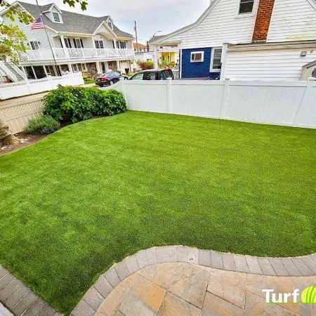 a yard with a fence and a building in the background