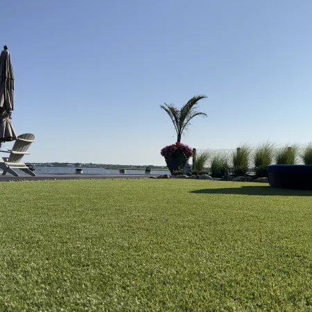 a couple of tents in a grassy field by a body of water