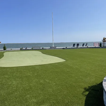 a golf course with a body of water in the background