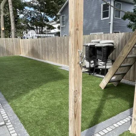 a backyard with a grill and a wood fence