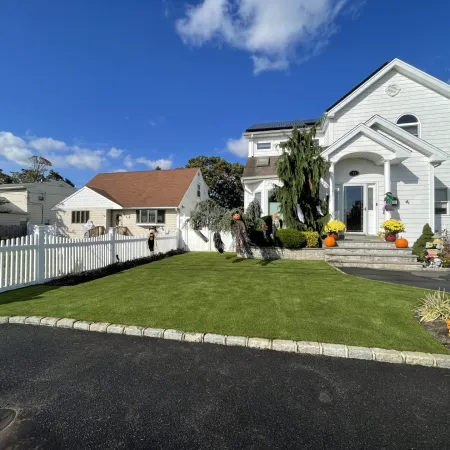 a white house with a lawn and a fence