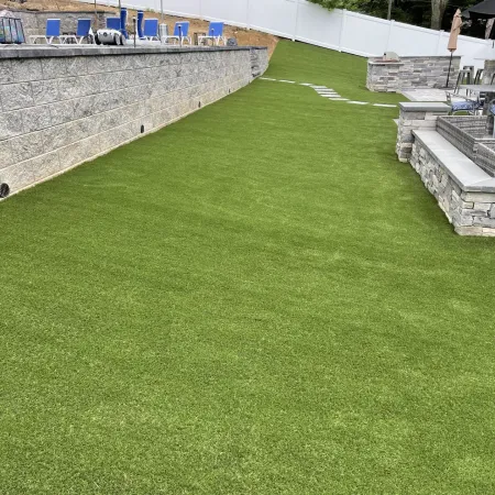 a grassy area with a fence and a building in the background