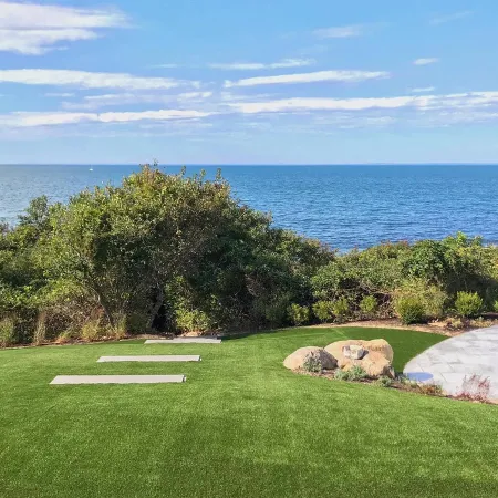 a golf course with a body of water in the background