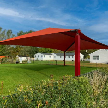 a red structure in a grassy field
