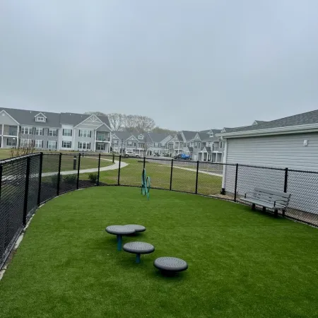 a grassy area with a fence and benches in it