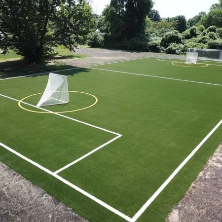 A well-maintained soccer field featuring two goals, marked lines, and a vibrant green turf under clear skies.