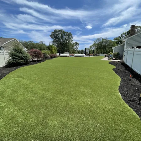 a grassy yard with buildings and trees