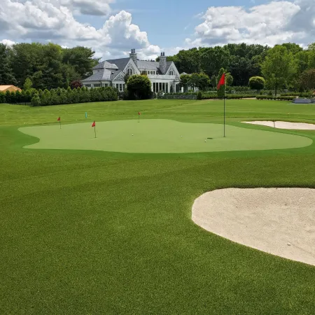 a golf course with a large house in the background