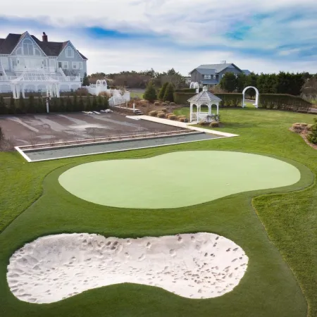 a golf course with a large house in the background