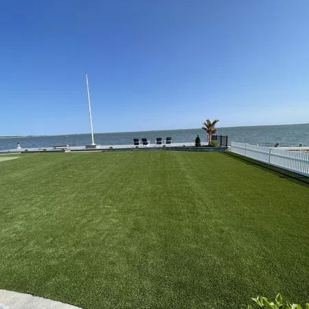 a grassy area with a body of water in the background