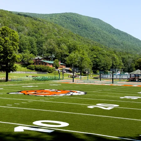 a football field with a hill in the background