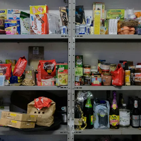 Metal shelves stocked with various food items including snacks, beverages, jars, and boxes in a storage room.