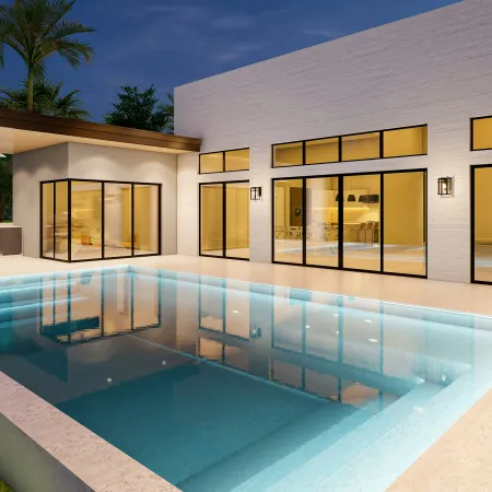Modern house exterior with large glass windows and a lit swimming pool at night under a clear sky.