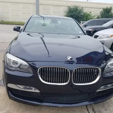 Front view of a dark blue BMW car parked outdoors showing headlights and kidney grille.