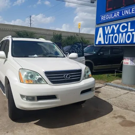 White Lexus SUV parked near Wycliff Automotive sign on a sunny day in a service lot