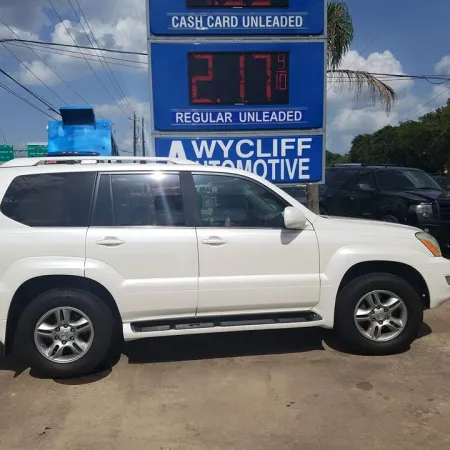 White SUV parked in front of a gas station sign showing regular unleaded price at $2.17 per gallon.
