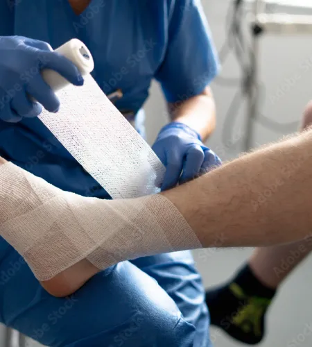 Medical professional wrapping injured foot with bandage in clinical setting for injury treatment