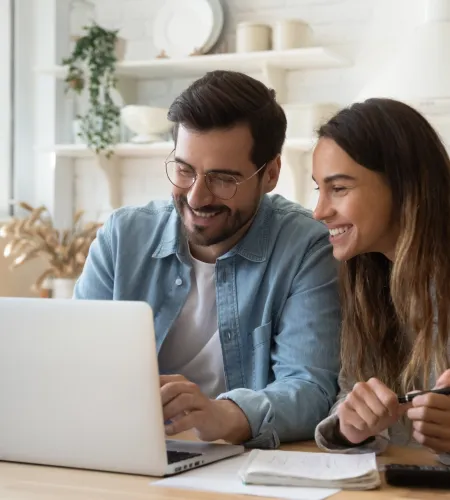 a man and a woman looking at a laptop