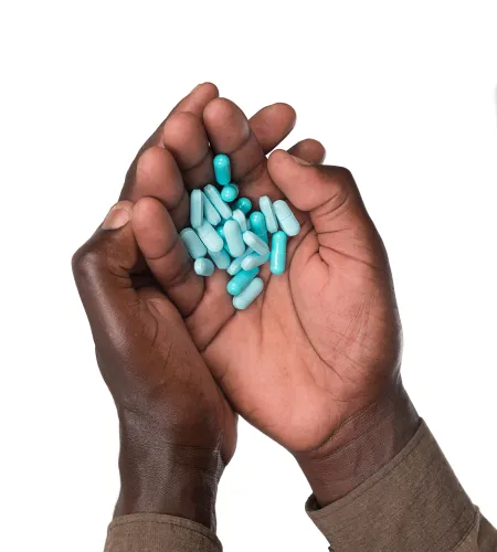 a pair of hands holding pills