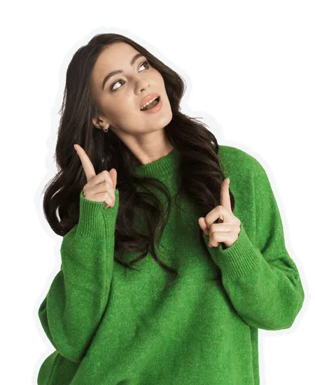 Young woman in green sweater looking up and pointing with both hands, expressing curiosity or discovery.