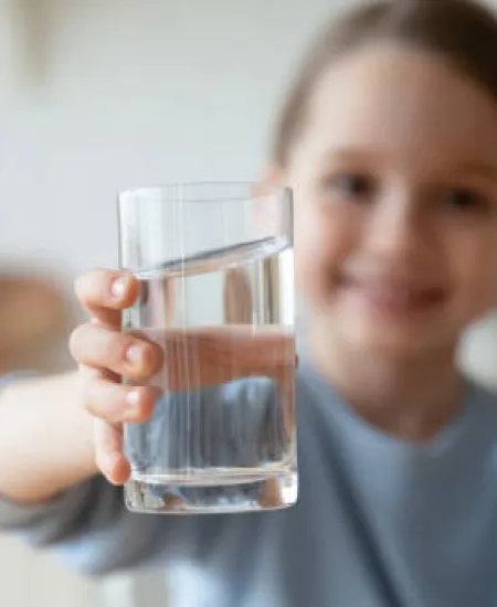 a girl holding a glass of water