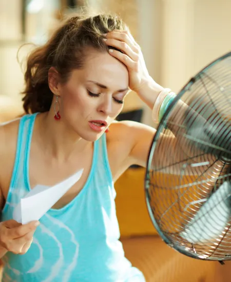 a woman cooling off in front of a fan