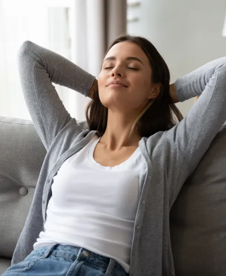 a woman sitting on a couch breathing clean air