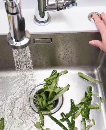 a person using the garbage disposal