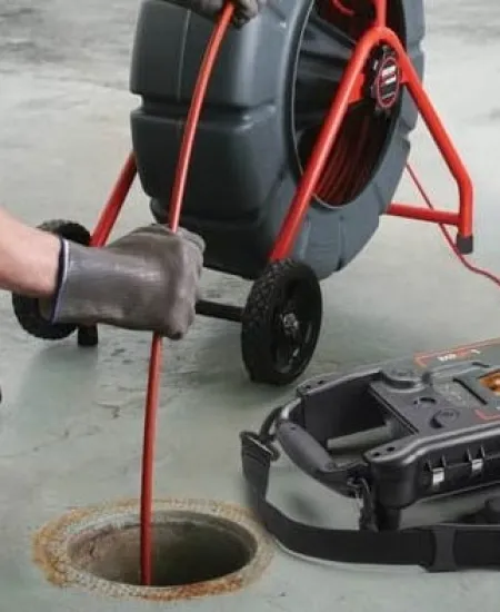 a person working on a backed up sewer line